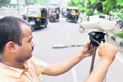 A technician installs a CCTV camera on the busy Ferozepur Road in Ludhiana 