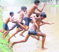 Boys jump in the Vallah canal in Amritsar