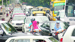 Vehicles negotiate a waterlogged road near the Tribune chowk after rain in Chandigarh on Friday; and (below) a long traffic jam was witnessed after the rain at Sectors 20-30-32-33 roundabout. The snarl-up lasted for around four hours till 3 pm