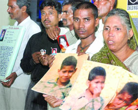 Parents of missing children show photographs of their kids in New Delhi 
