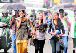 Three girls seem to enjoy a drizzle in Dehradun on Friday