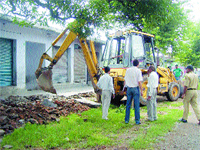 PWD officials remove encroachments on the state highway in Nurpur on Friday.