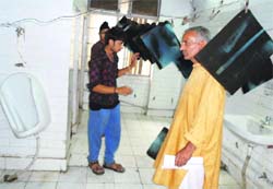 Patients and their attendants wait in a toilet at the GMCH in Jammu on Friday to collect the X-ray films. 