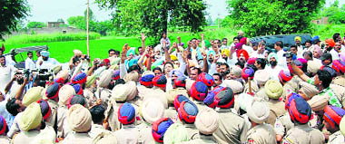 Policemen stop the Congress men at the entry point of Gobindpura village in Mansa on Friday.