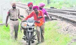 The body of constable Bhajan Singh being taken away on a motorcycle near the Gill railway station