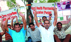 Rural health pharmacists observing an indefinite dharna outside the Mini-secretariat in Bathinda on Sunday