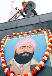 A member of the Kamboj Sabha raises slogans after garlanding the statue of Shaheed Udham Singh in Amritsar