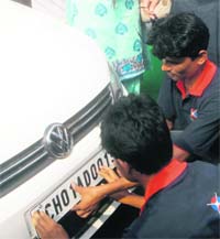 A high-security registration plate being fixed on a car in Sector 42, Chandigarh