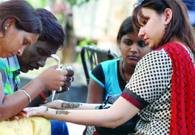 Girls getting henna on their hands on the occasion of Teej at Connaught Place in New Delhi on Monday.