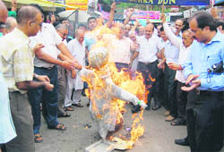 Cloth merchants burn an effigy of the state government in protest against the imposition of VAT on cloth in Dehradun 