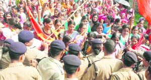 Police personnel stop protesting ASHA workers from proceeding towards the residence of the Uttarakhand Chief Minister, in Dehradun 