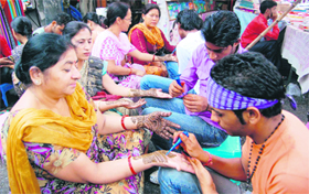 Women get mehndi applied on their hands in Dehradun on Monday. 
