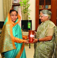 Delhi Chief Minister Sheila Dikshit presents a sapling to President Pratibha Devi Singh Patil at the Rashtrapati Bhavan while apprising her about an ongoing