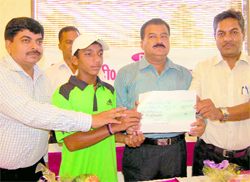 Dhruv Pal, a promising tennis player from Uttarakhand, is given a cheque for Rs 21,000 by an office-bearer of the D&D Global Sports Promoters at a function in Dehradun on Tuesday
