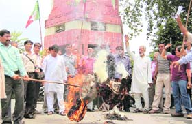 Workers of the Uttarakhand Kranti Dal (Panwar faction) burn an effigy of the state government in Dehradun on Tuesday