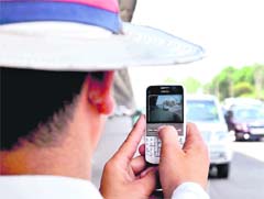 A traffic marshal captures a traffic rule violator on his cellphone at Shankar Chowk, Gurgaon