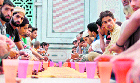 Devotees wait to break the fast on the first day of Ramzan in Jammu on Tuesday.