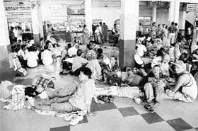 Stranded passengers wait at the Gauhati railway station on Tuesday