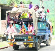 A vehicle carries devotees near the Chamunda Devi temple, posing a risk to their lives.