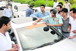 Members of PUSU paste party posters on their vehicles at Panjab University in Chandigarh