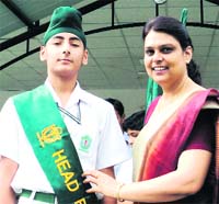 Urmil Verma, Principal of Delhi Public School, felicitates the head boy of the school at an investiture in Dehradun 