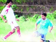Two players vie to take control of the ball in a rain-soaked match of the Lala Nemi Dass Memorial Dehradun Football League in Dehradun 