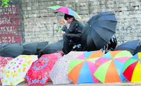 An umbrella vendor awaits customers near Sector 13 in Karnal. 