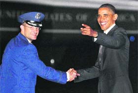 President Barack Obama with Col Kenneth Rizer to listen to members of the media and crew sing him happy birthday as he arrives from Chicago on Air Force One on Thursday