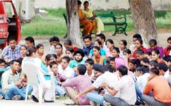 Going the Shantiniketan way!: Students squat on the ground to attend a lecture at the Government Rajindra College in Bathinda