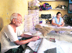 A man and a woman make kites in Jammu on Friday