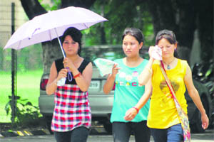 The scorching Sun makes it difficult for these girls to walk to their college in Jammu. 
