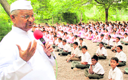 Social activist Anna Hazare addresses schoolchildren at Ralegan Siddhi village in Maharashtra on Friday