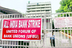 Bank employees hold placards during a nationwide bank strike in Ahmedabad on Friday
