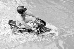 A motorcyclist wades through a flooded street after heavy rains at Nabin Nagar in Guwahati on Friday