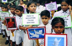 Schoolchildren hold placards during a peace march to mark the Hiroshima Day at Jantar Mantar in New Delhi on Saturday