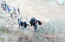 Tourists try to take a risky way as the cloudburst has ruined the road.