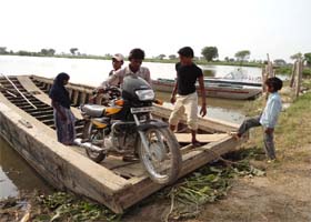 Residents of Mohar Jamsher village use wooden boats to cross the Sutlej