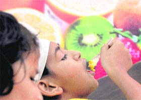 An autistic child of Darpan enjoys a treat at the opening of an ice-cream parlour in Ludhiana