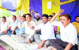 Workers of the UKD hold a dharna in Dehradun on Monday. 