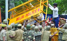 BJYM activists try to remove the police barrier during their rally