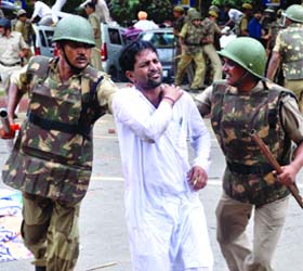 Policemen detain a protestor at the rally in New Delhi on Tuesday
