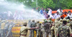 Policemen use water cannons to stop the BJP Yuva Morcha activists trying to break the police barriers during the Sansad ghirav against black money and corruption in New Delhi on Tuesday