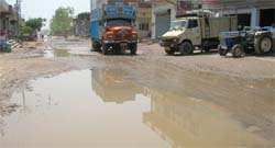 A damaged road outside the bus stand on the Malwal road. 