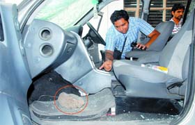 The owner of the damaged vehicle shows the stone that was thrown by unknown persons at the vehicle outside the district court in Mohali on Wednesday