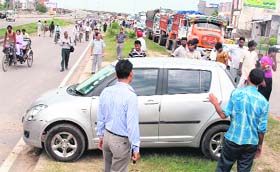 Holding traffic to ransom: Harassed commuters cross a divider following a jam caused by suppliers of construction material for three hours on the Zirakpur-Kalka highway near Baltana on Wednesday morning
