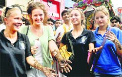 Foreigners display mehndi patterns on their hands in Dehradun on Thursday