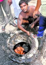 Sewermen desilting a sewer manually without wearing any safety equipment near Master Tara Singh Nagar in Jalandhar.