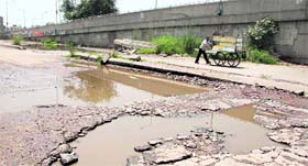 A pot-holed road alongside bus stand flyover in Jalandhar cries for attention.