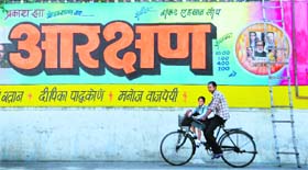 A cyclist passes by a poster of ‘Aarakshan’ at Aarti Cinema in Ludhiana on Thursday