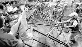 Democratic Youth Federation of India workers break police barricade during a clash in Kozhikode on Thursday.